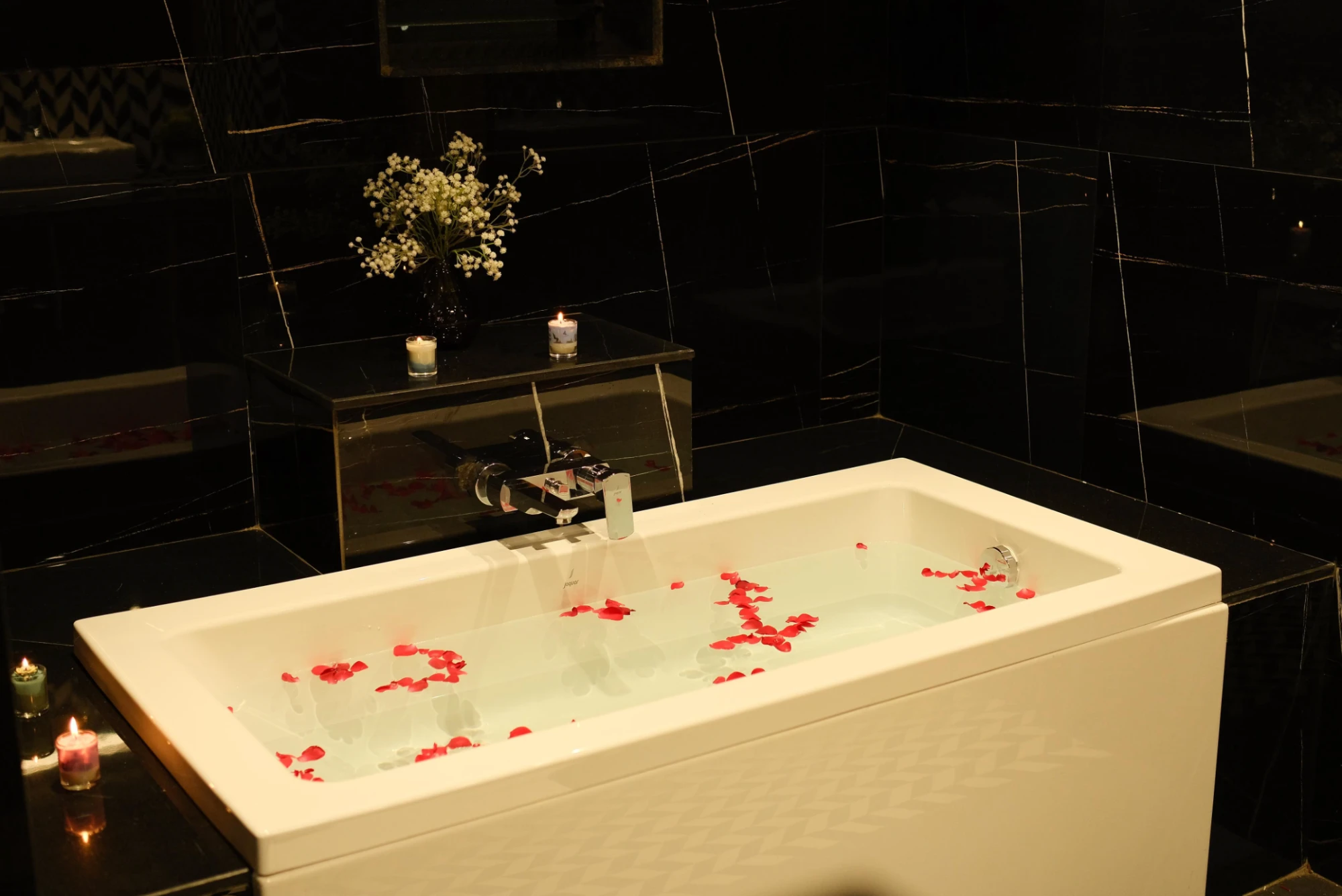 Suite bathtub with rose petals and candles